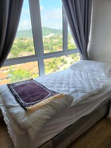 Cama en habitación con ventana grande en Mahkota Valley Suite Apartment Indera Mahkota Kuantan en Kuantan