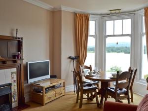 a living room with a table and a television at Mere View in Ambleside