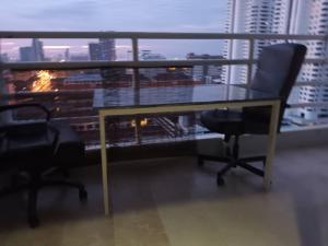 - biurko i krzesła w pokoju z widokiem na miasto w obiekcie Viewtalay condo 5 D w Pattaya South