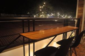 uma mesa de madeira na varanda à noite em Ginto Residence - City Center em Coron
