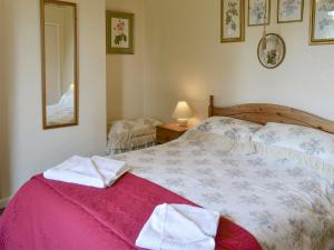 a bedroom with a bed with towels on it at Peasholm in Thornton Dale
