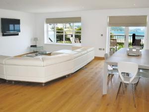 a living room with a white couch and a table at Gylly Beach View - Tor in Falmouth