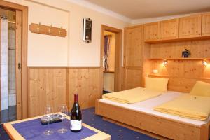 a bedroom with two beds and a table with wine glasses at Pension Sonneck in Neukirchen am Großvenediger