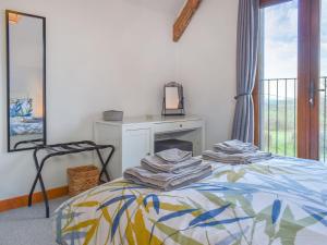 a bedroom with a bed with a fireplace and a mirror at Dairy Barn - Uk37424 in Langtree