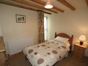 a bedroom with a bed and a lamp and a window at Spring Cottage-e3846 in Kirk Ireton