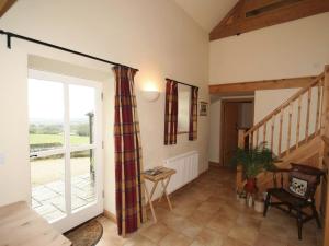 a living room with a sliding glass door and a staircase at Spring Cottage-e3846 in Kirk Ireton