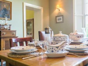 a wooden table with plates and dishes on it at Tilney Hall in Terrington Saint John