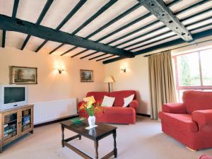 a living room with red chairs and a tv at Fox Cottage - E4510 in Chipping Sodbury