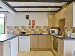 a kitchen with wooden cabinets and a white refrigerator at Bay - E4482 in Ludham