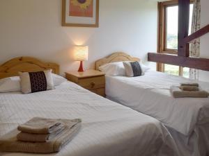 a bedroom with two beds with towels on them at Bay - E4482 in Ludham