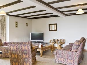 a living room with couches and a tv at Bay - E4482 in Ludham
