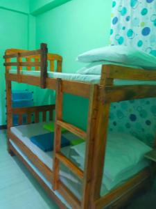 Letto a castello in legno in camera di CJ Transient house a Baguio