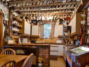 uma cozinha com armários brancos e uma mesa em Chapel Cottage em Pont Sticill