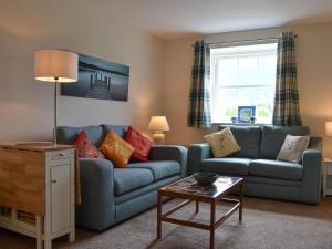 a living room with a blue couch and a table at The Retreat in Nether Wasdale