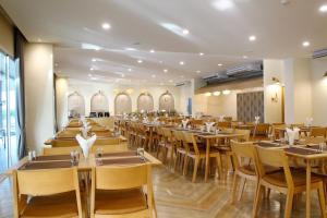 uma grande sala de jantar com mesas e cadeiras em The Leisure Hotel em Bang Bo