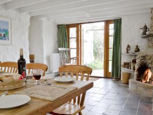 uma sala de estar com uma mesa e uma lareira em Lordship Farmhouse em Saint Lawrence