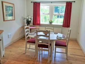 a dining room with a white table and chairs at Bumble Cottage in Newton on the Moor