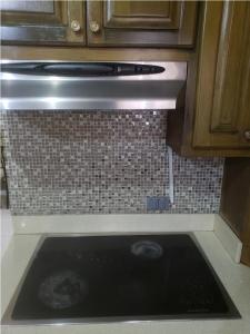 a stove top oven in a kitchen with a tile wall at Pearl of the City NEW KINGSTON in Kingston