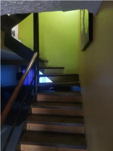 a set of stairs in a room with green walls at Pearl of the City NEW KINGSTON in Kingston