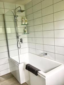 a white bathroom with a tub and a shower at Panoramic Views - House in Ahipara