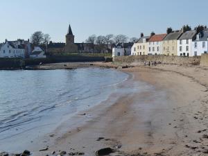 a view of a beach with houses in the background at Rockview in Cellardyke