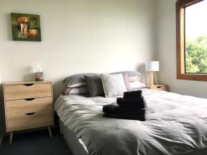 a bedroom with a bed and a wooden dresser at Panoramic Views - House in Ahipara