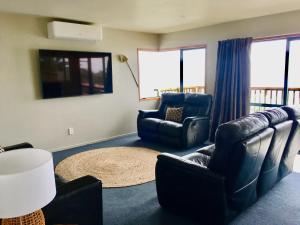 a living room with two chairs and a couch at Panoramic Views - House in Ahipara