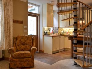 sala de estar con silla y cocina en Pegs Place, en Windermere