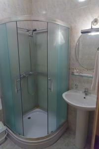 a bathroom with a glass shower and a sink at Laetu in Atyrau