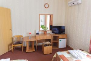 a room with a desk with a television and a mirror at Laetu in Atyraū