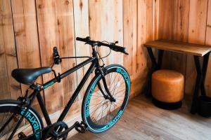 a bike parked against a wooden wall next to a table at Guesthouse Shimashima in Matsumoto