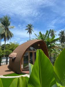 a small circular house with a palm tree in the background at Found Mansion in Pantai Cenang