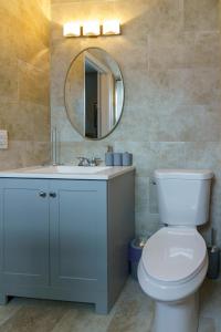een badkamer met een wit toilet en een spiegel bij Metaverse Manor Hardrock Stadium in Miramar