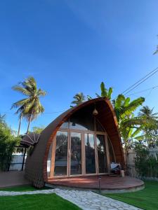 a circular house with a large window in a yard at Found Mansion in Pantai Cenang