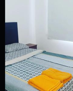 Un dormitorio con una cama con toallas amarillas. en departamentos corrientes en Corrientes