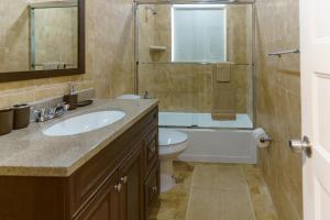 a bathroom with a sink and a toilet and a shower at Metaverse Manor Hardrock Stadium in Miramar