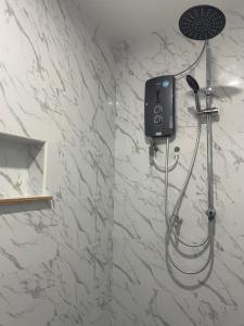 La salle de bains est pourvue d'une douche avec un pommeau de douche. dans l'établissement The Pancarona24 Homestay forMuslim, à Ipoh