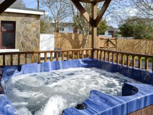 a jacuzzi tub with snow in a backyard at Ysgubor Wen in Burry Port
