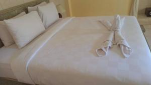 uma cama branca com um animal de toalha em Tasikdumun homestay em Amed