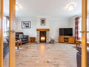 a living room with a fireplace and a tv at Gartclach-uk40001 in Gartmore