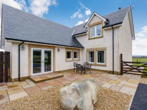 a detached house with a patio and a rock at Gartclach-uk40001 in Gartmore
