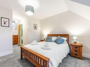 een slaapkamer met een groot bed met een houten frame bij Gartclach-uk40001 in Gartmore