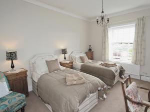 a bedroom with two beds and a chair and a window at West View Cottage - E5386 in Two Dales