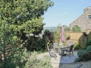 a patio with a table and chairs and an umbrella at West View Cottage - E5386 in Two Dales