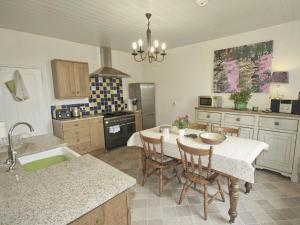 eine Küche mit einem Tisch mit Stühlen und einem Waschbecken in der Unterkunft West View Cottage - E5386 in Two Dales