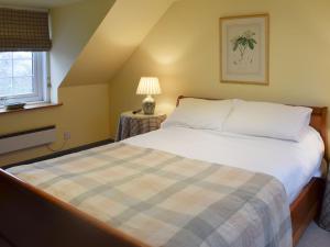 a bedroom with a bed and a lamp on a table at But n Ben in Lochdon