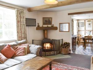 a living room with a couch and a fire place at The Old Granary in Newent