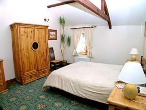 エバーショットにあるParlour Cottageのベッドルーム1室(ベッド1台付)、木製キャビネットが備わります。