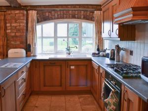 a kitchen with wooden cabinets and a sink and a window at Meadow View - Ijv in Brigham