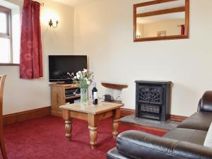 a living room with a table and a fireplace at Beech Lodge in Buckland Brewer